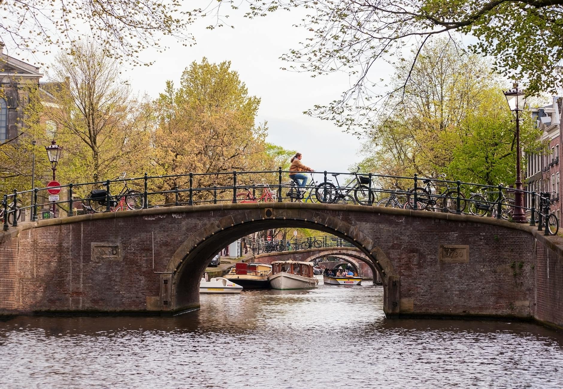 Solo traveler cycling along Amsterdam canal