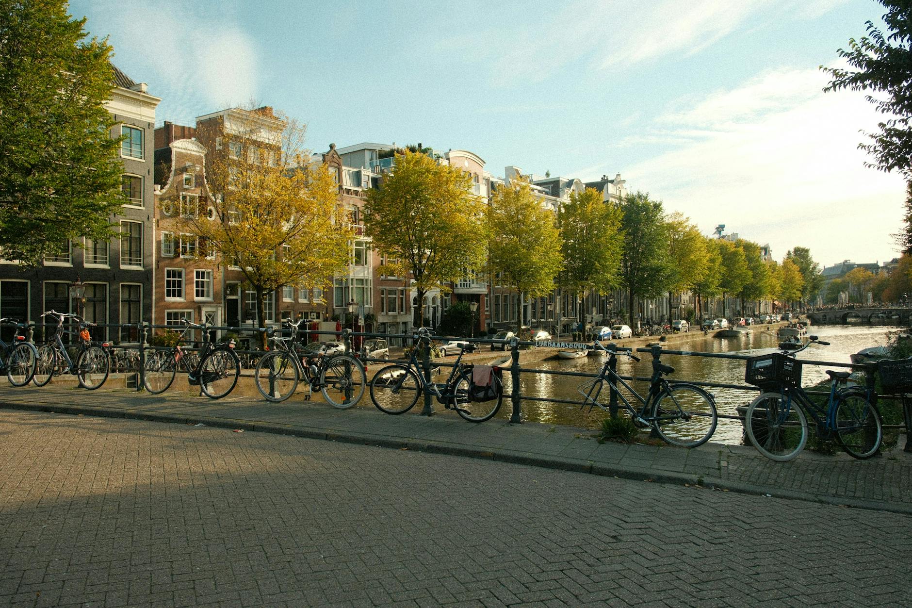 Amsterdam canal in autumn with golden leaves and bicycles - best time to visit Amsterdam