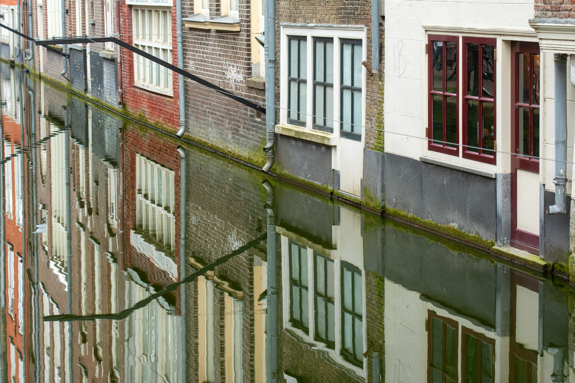 Delft canal with traditional Dutch houses and blue sky