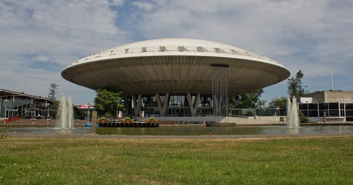 The Evoluon, a concrete flying-saucer building on twelve V-shaped legs beside a pond in Eindhoven
