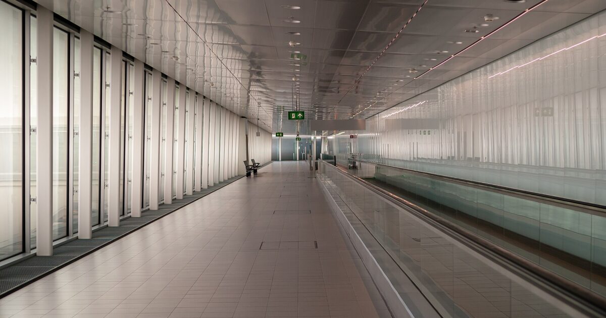 A long airside connecting corridor with a moving walkway between Schiphol piers