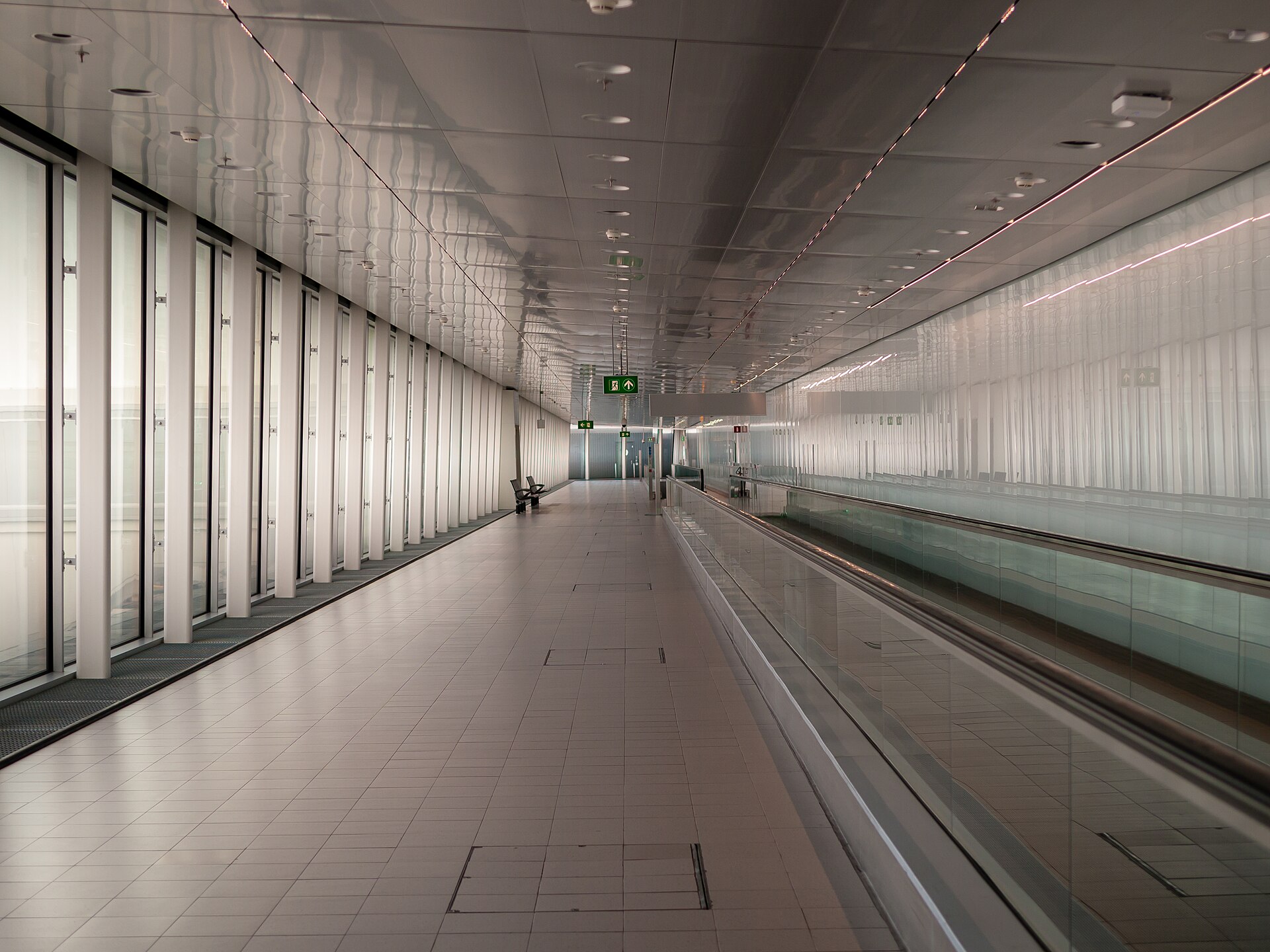 A long airside connecting corridor with a moving walkway between Schiphol piers