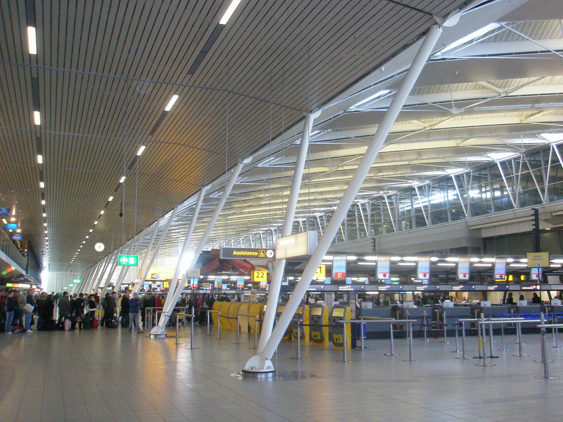 Check-in desks and self-service kiosks inside a Schiphol departure hall