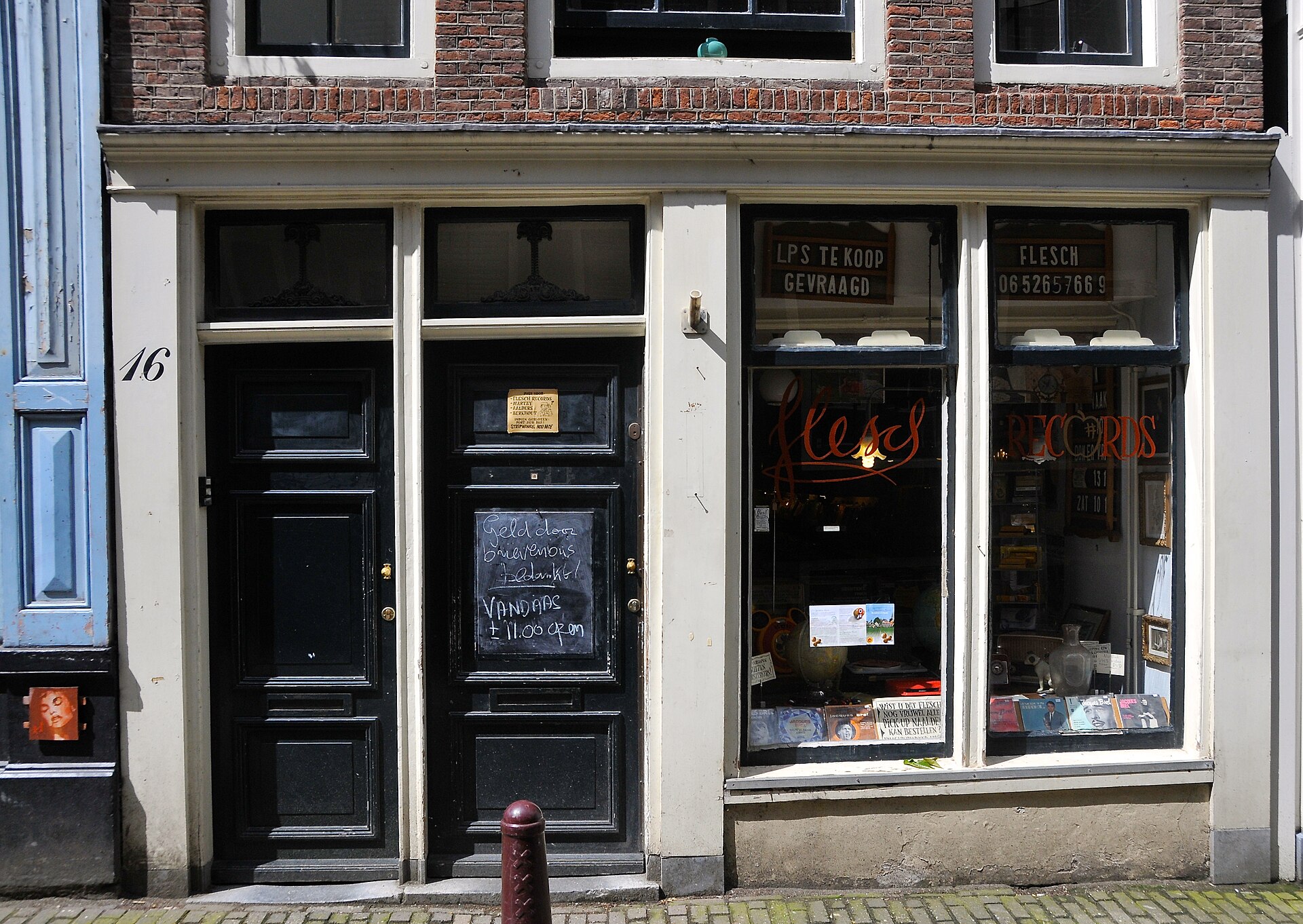 Flesch Records on Amsterdam's Noorderkerkstraat has a small window displaying record sleeves and audio equipment beside black-painted doors.