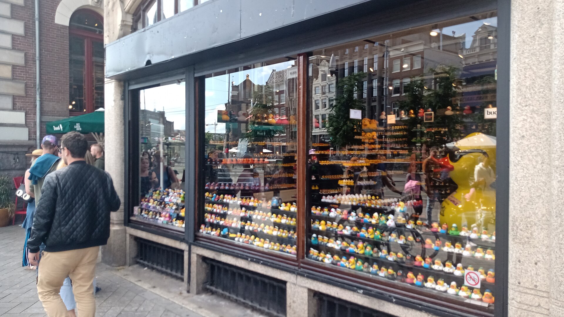 Passers-by walk beside a Kalverstraat shop in Amsterdam whose windows display rows of colourful rubber ducks.