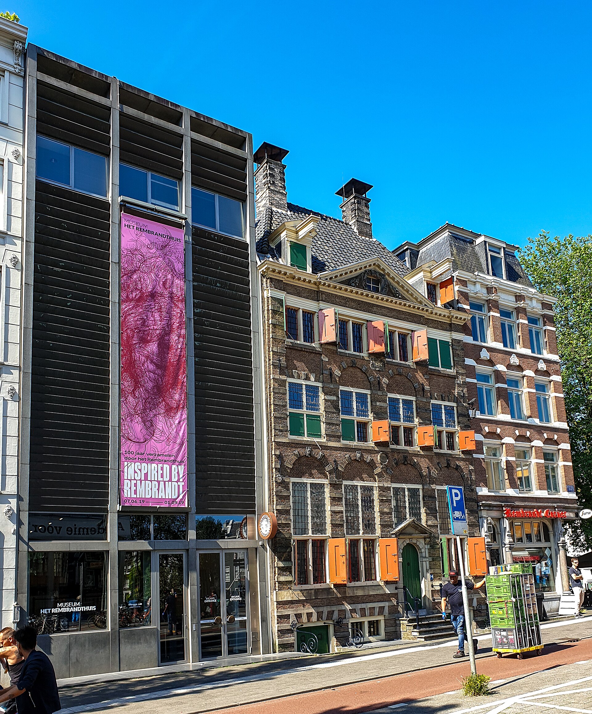 The Rembrandt House Museum in Amsterdam has red and green shutters beside a modern glass-fronted entrance wing.